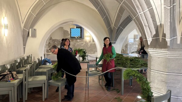 Drei der Helfer*innen beim Schmücken und Herrichten der Ostergirlande im Ratskeller des Schmöllner Rathauses