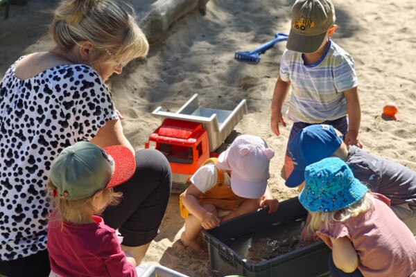 Krippenkinder spielen im Sandkasten Krippenkinder spielen im Sandkasten