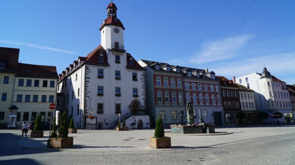 Aufnahme des Schmöllner Rathauses mit umliegenden Gebäuden und dem davor liegenden Marktplatz