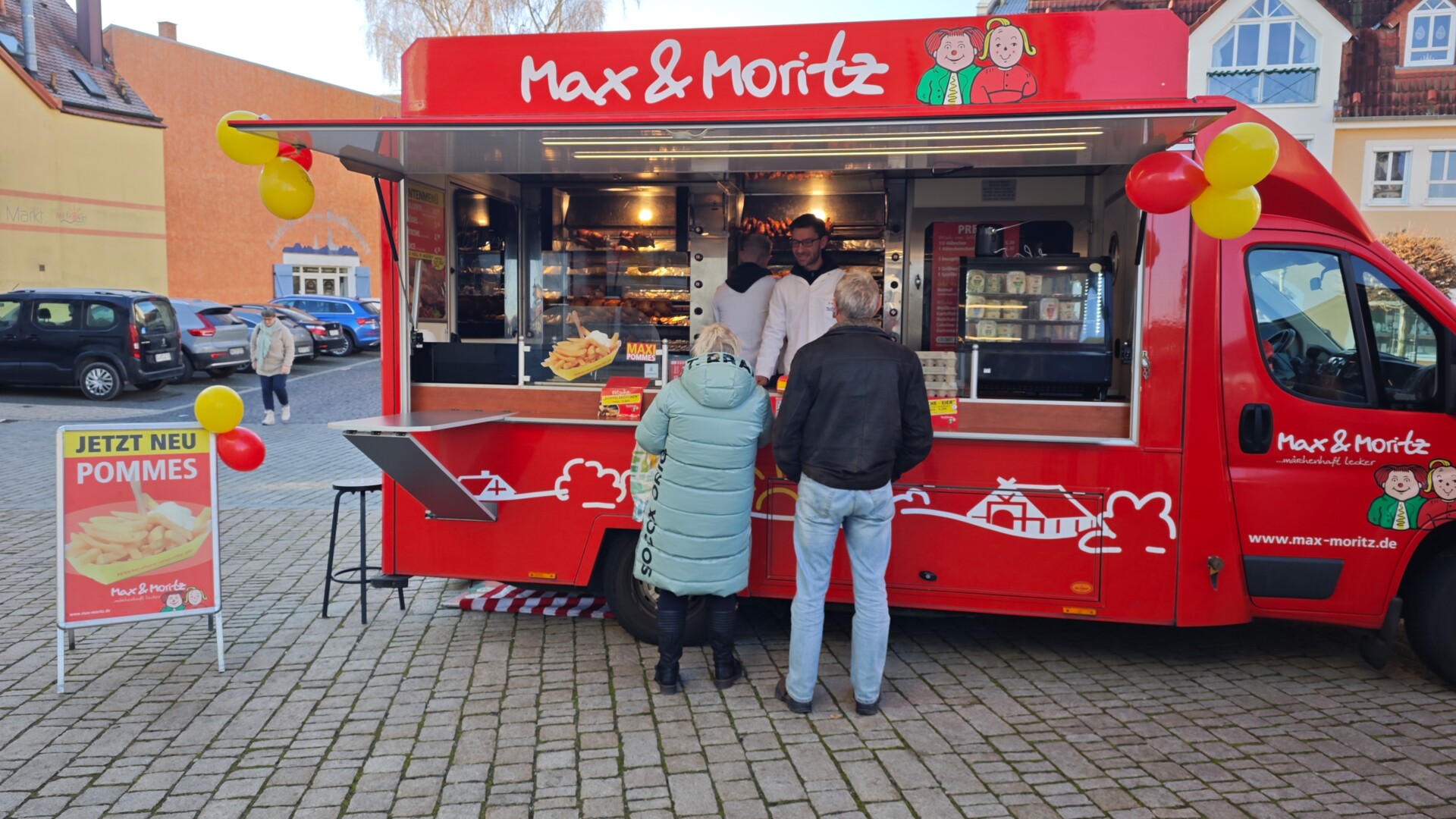 Max und Moritz Hähnchengrill Max und Moritz Hähnchengrillwagen mit Menschen davor, die gerade einkaufen.