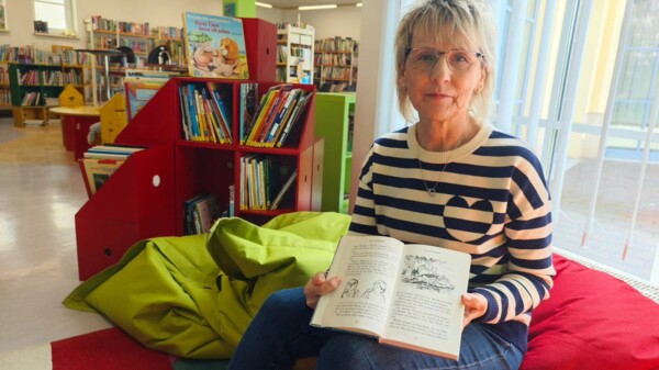 Heike Milke vom Bibliotheksteam hält das gelesene Buch in die Höhe.