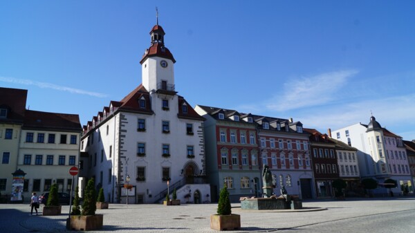 Aufnahme des Schmöllner Rathauses mit umliegenden Gebäuden und dem davor liegenden Marktplatz