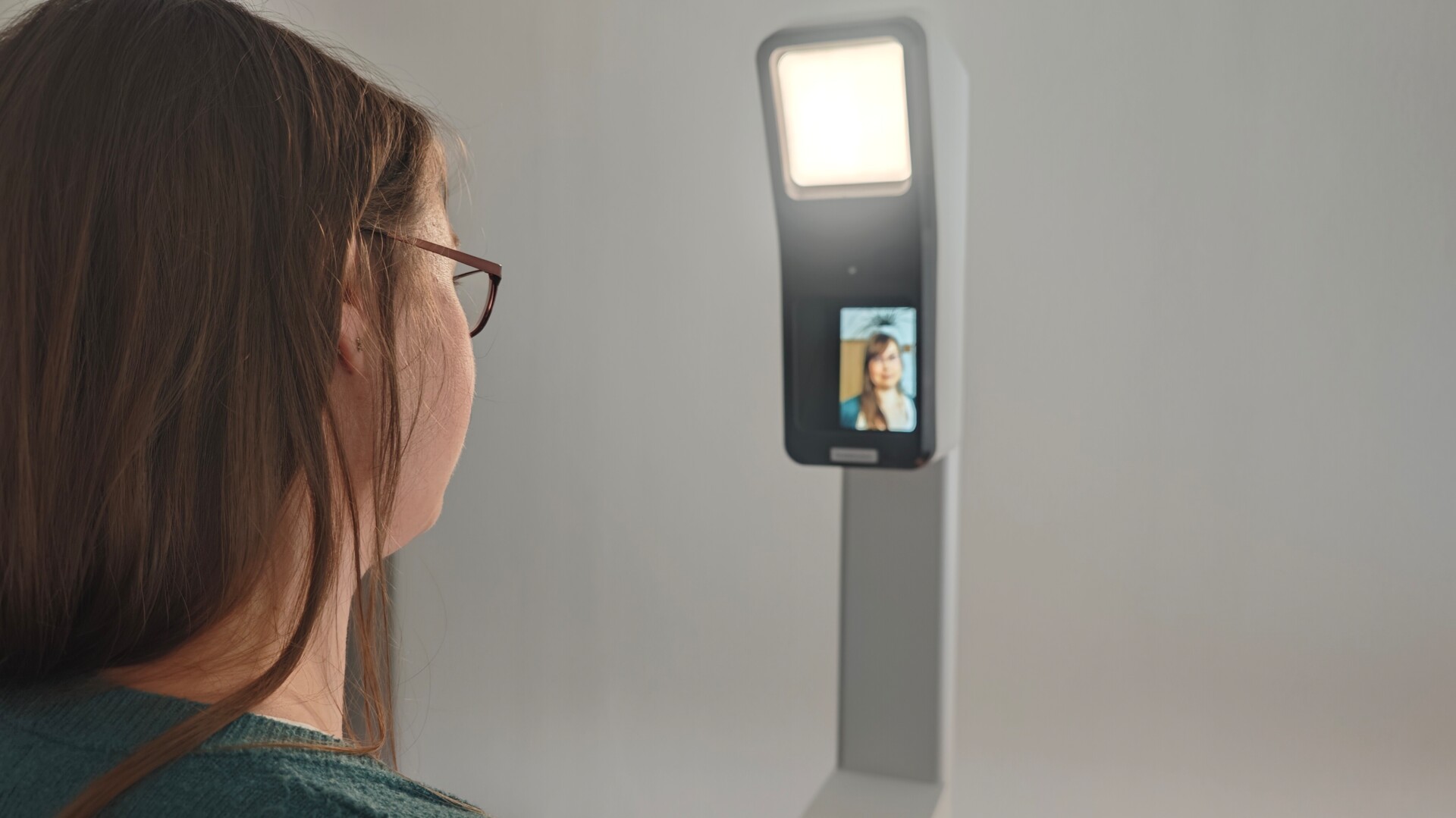Eine Person steht vor einem neuen Foto-Terminal. Eine Person steht vor einem neuen Foto-Terminal.