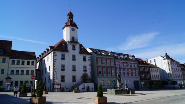 Aufnahme des Schmöllner Rathauses mit umliegenden Gebäuden und dem davor liegenden Marktplatz